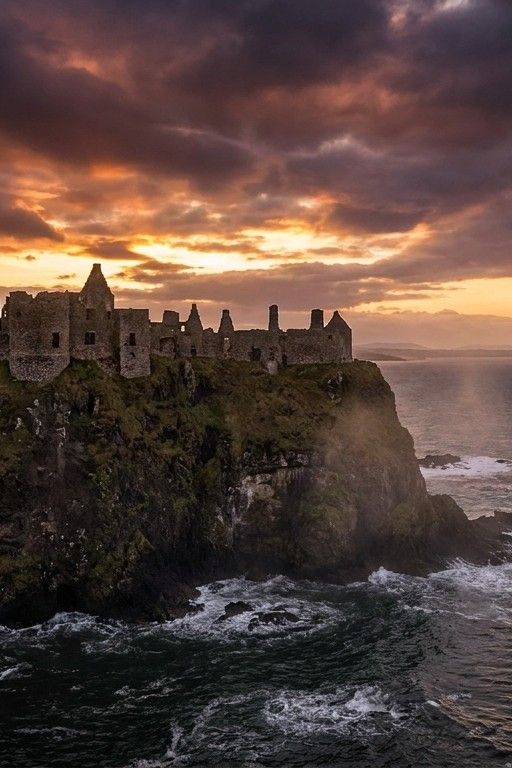 Medieval castle on a cliff overlooking the sea at dawn, dramatic clouds, epic scale
